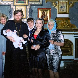 Group portrait during a christening ceremony in a church.