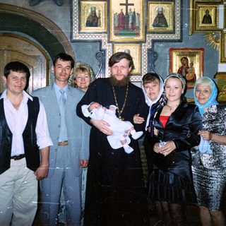 Group portrait during a christening ceremony in a church.