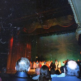 Audience viewing a stage performance with performers visible.