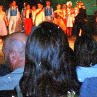 Audience viewing a stage performance with performers visible.