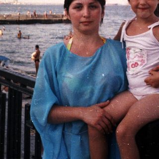Woman and child on a beach, enjoying a seaside view.