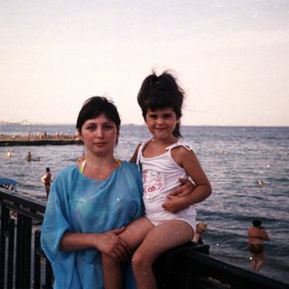 Woman and child on a beach, enjoying a seaside view.
