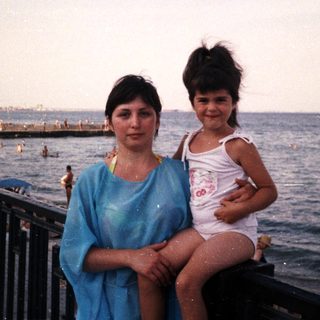 Woman and child on a beach, enjoying a seaside view.