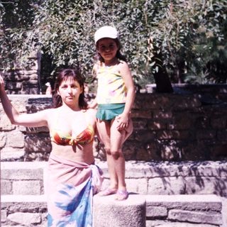 Woman and child posing near ancient stone ruins.