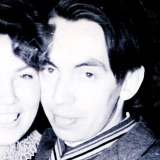 Couple posing for a black and white portrait.