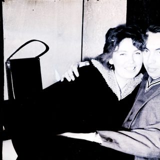 Couple posing for a black and white portrait.