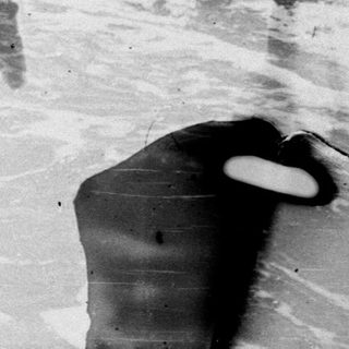 Person in the water, appearing to be caught by a wave.