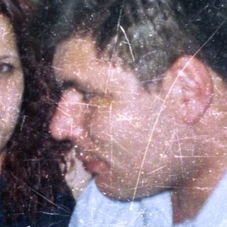 Three people are close together in a slightly blurry photo.
