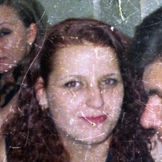 Three people are close together in a slightly blurry photo.