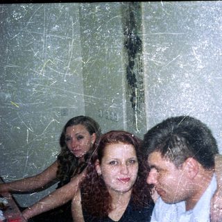 Three people are close together in a slightly blurry photo.