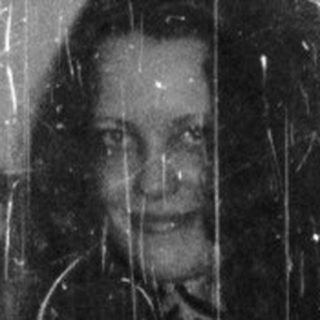 Woman in leopard print dress stands near a door.