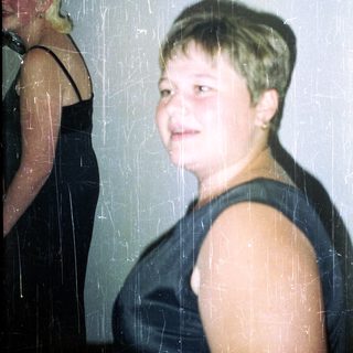 Two people, one with short hair, stand in a room.