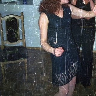 Two women in dresses dancing in a room.