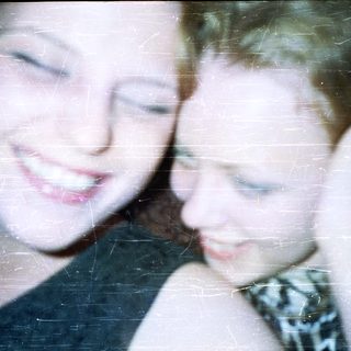 Two young women with short hair, close together.