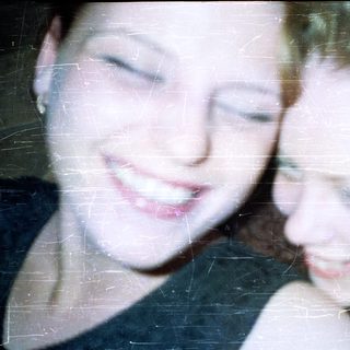 Two young women with short hair, close together.