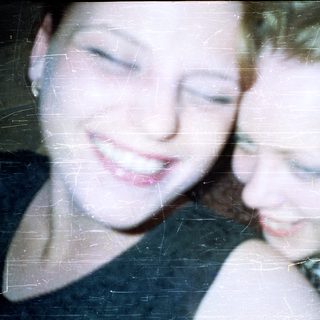 Two young women with short hair, close together.