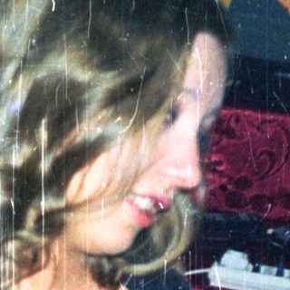 Woman dancing near a piano in a room.
