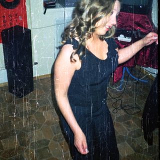 Woman dancing near a piano in a room.