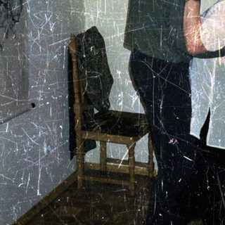 Man embraces a woman in a dimly lit room.