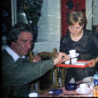 Three people seated at a table in an indoor setting.