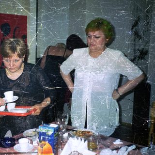Three people seated at a table in an indoor setting.