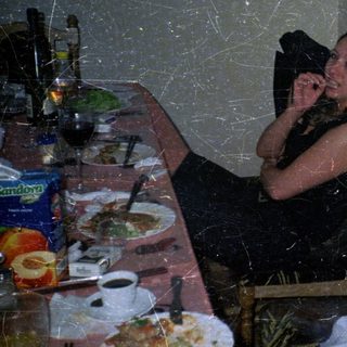 Couple seated at a table with food and drinks.