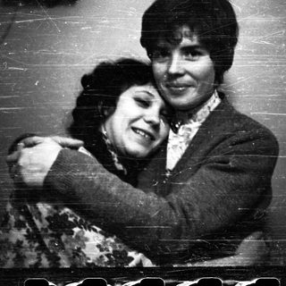 Here's a brief summary of the image: Two people embracing in a black and white photograph.