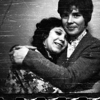 Here's a brief summary of the image: Two people embracing in a black and white photograph.
