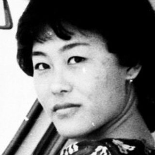 Woman in traditional dress sits in a vintage car.