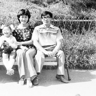 Family portrait on a park bench in black and white.