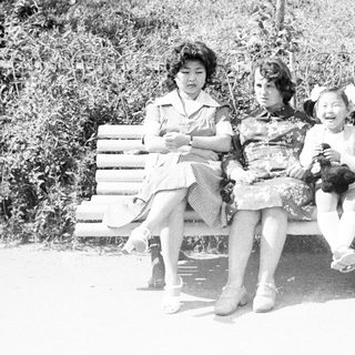Family portrait on a park bench in black and white.