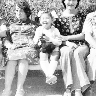 Family portrait on a park bench in black and white.