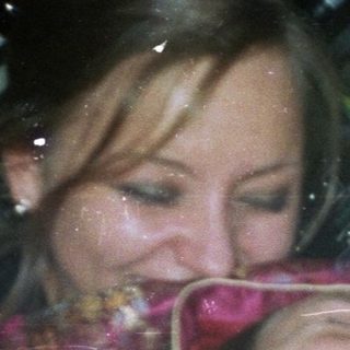 Here's a brief summary of the image: Woman appears distressed, holding her face near a bar.