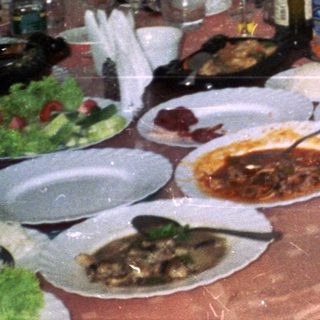 Two women at a table with food and drinks.