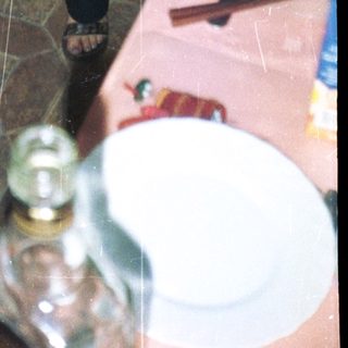 Woman in black dress playfully poses near table setting.