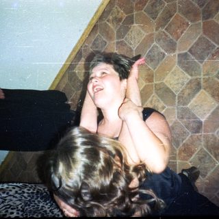 Here's a brief summary of the image: Woman is pinning a person to the floor.