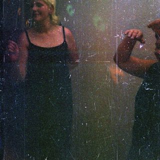 Here's a brief summary of the image: Woman and man seen through a rain-streaked window.