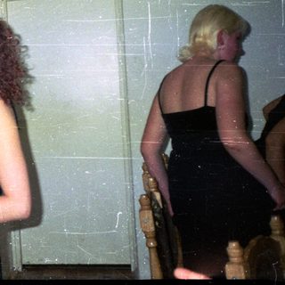 Two women sing into microphones at an indoor gathering.