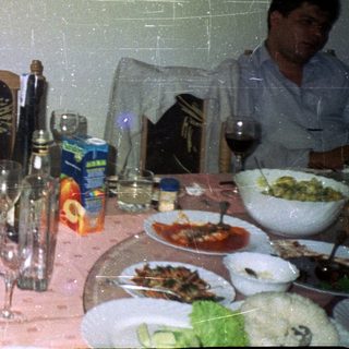 Men seated at a table with food and drinks.