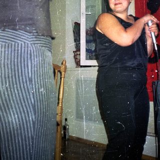 Person holding microphone, standing near a doorway.