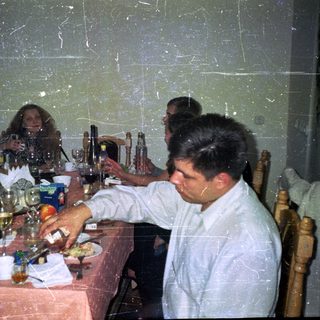 People dine at a table with drinks and food.