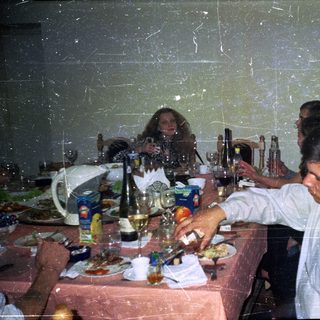 People dine at a table with drinks and food.