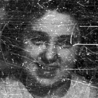 Here's a brief summary of the image: Two men appear in a faded, scratched black and white photograph.