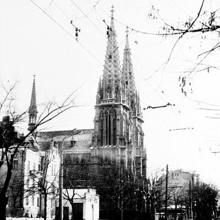 Black and white photo of a church with tall spires.