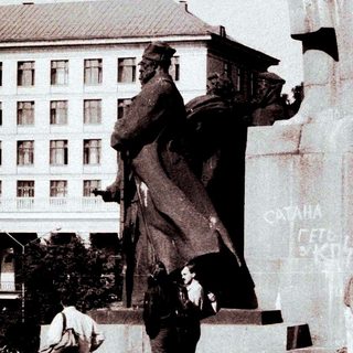 Children play near a statue in a public space.