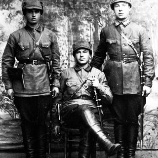 Three men in military uniforms pose for a portrait.