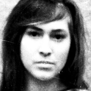 Black and white portrait of a young woman, striped shirt.
