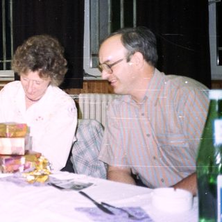 People seated at a table, celebrating with food and drinks.