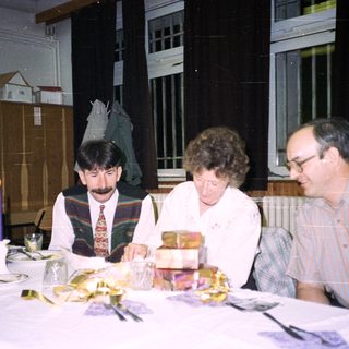 People seated at a table, celebrating with food and drinks.