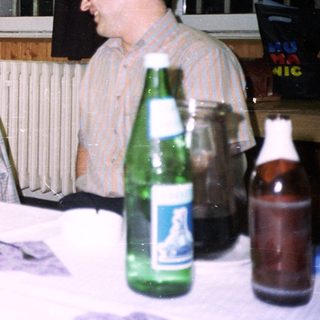 Three people seated at a table, gift exchange.